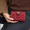 Μεσαίου μεγέθους πορτοφόλι με φερμουάρ στις γωνίες από χαρακτηριστικό τζιν